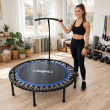 Woman beside a Bungee Fit fitness trampoline in a bright home workout studio.