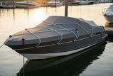 Black-and-white bungee cord straps securing a small boat on calm water