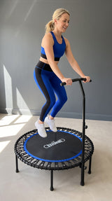 Woman exercising on a Bungee Fit rebounder while holding the padded handlebar.