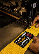 Close-up of yellow heavy-duty tree saver strap being sewn in the USA with reinforced stitching and The Original Tow Strap Made in USA label.