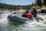 Inflatable raft with bungee cords securing gear; white lines with black specks